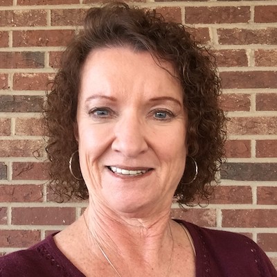 Donna Vanhorn smiling in front of a brick wall