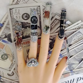 finger nail design on mannequin hand over several one hundred dollar bills